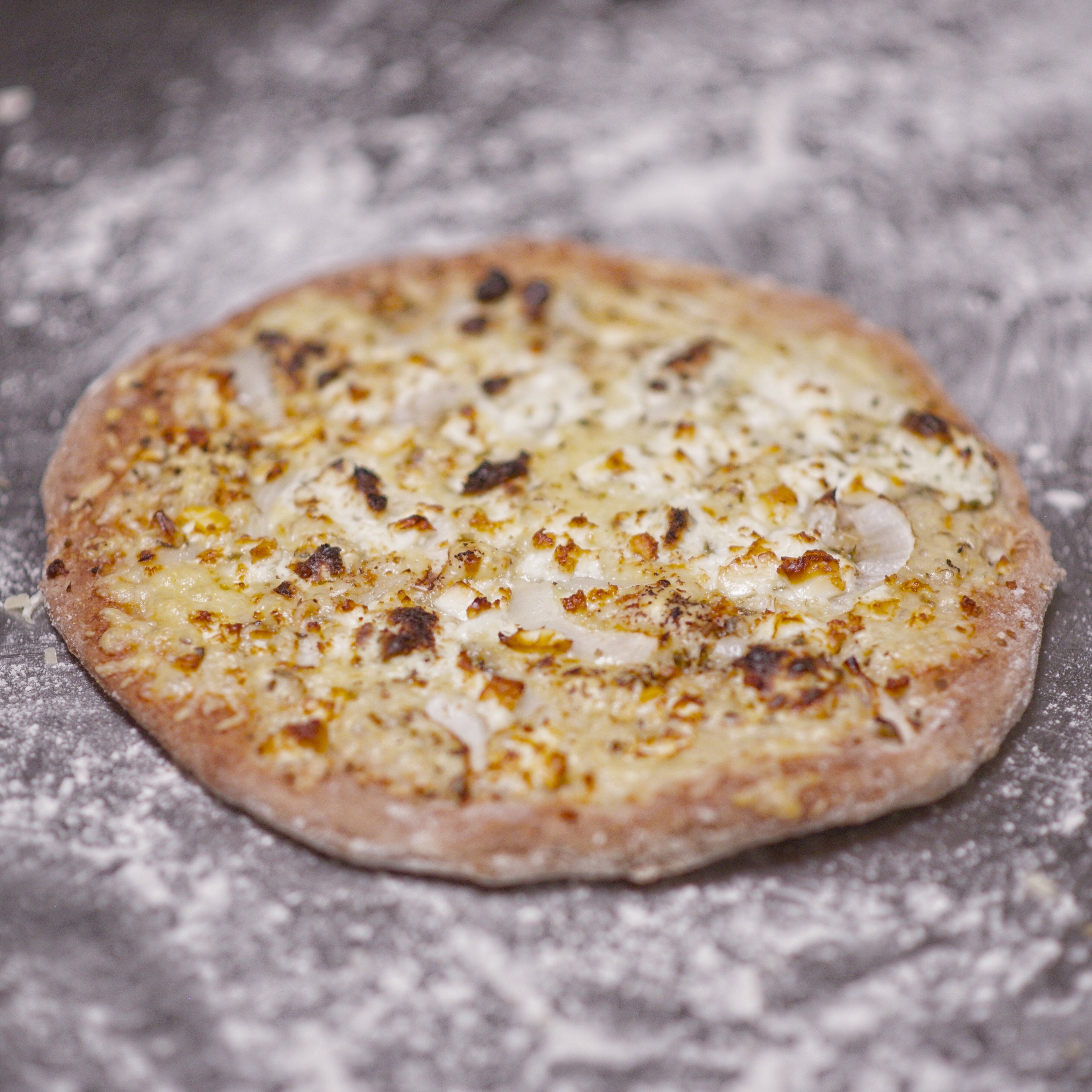 Glutenvrije zuurdesem pizza met een goudbruine, luchtige korst en gesmolten kaas